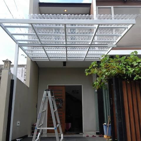 Kanopi Alderon berbahan UPVC bergelombang warna putih, cocok untuk rumah modern dan kedap suara saat hujan.