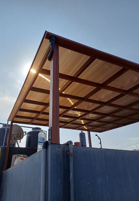Kanopi polycarbonate dengan rangka besi hollow galvanis di atas rooftop, tampak kokoh dan estetik melindungi area dari sinar matahari langsung.