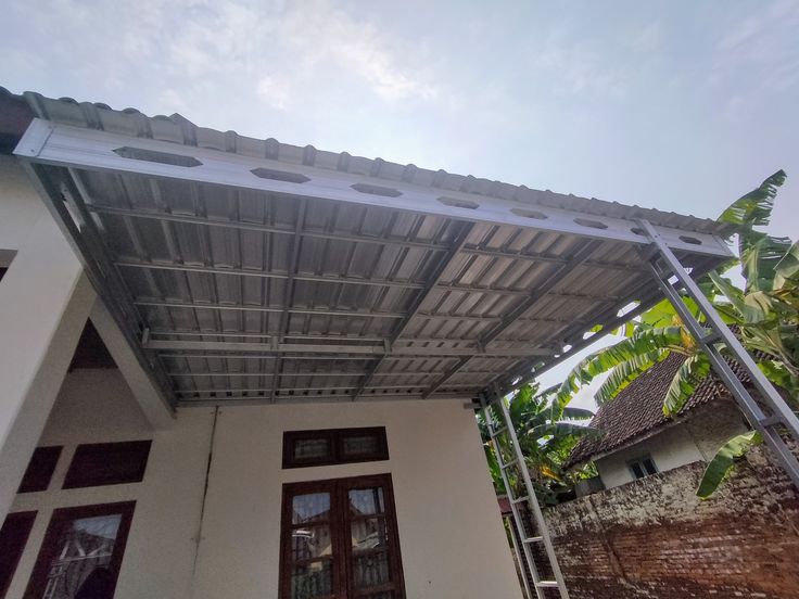 Kanopi baja ringan di rumah tinggal setelah musim hujan, terlihat bersih dan kokoh sebagai hasil dari perawatan dan cara merawat kanopi yang tepat.