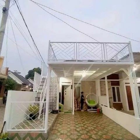 Struktur kanopi balkon tanpa atap berbahan besi putih dengan desain mezzanine minimalis di area rumah, lengkap dengan tangga dan taman kecil di bawahnya.