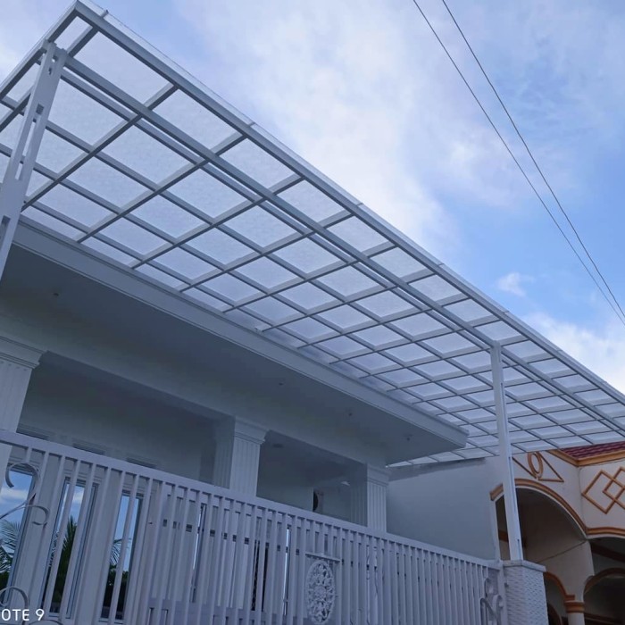 Kanopi polikarbonat transparan terpasang di rumah modern, desain elegan dari Bengkel Kanopi untuk perlindungan dan pencahayaan alami.