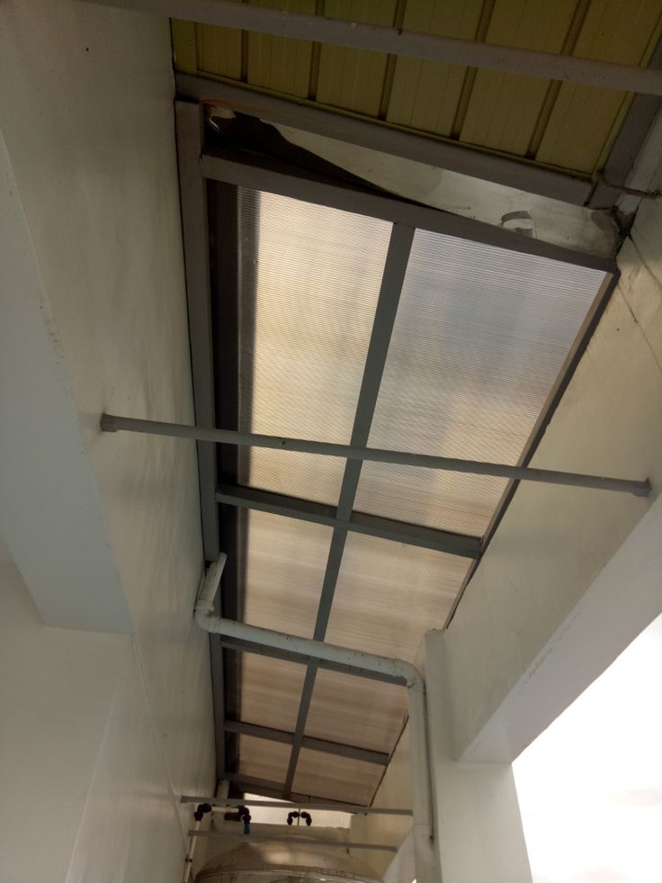 Kanopi twinwall polycarbonate Kanopi polycarbonate transparan dengan rangka besi hollow di lorong sempit — contoh pemasangan kanopi polycarbonate minimalis di area sempit.