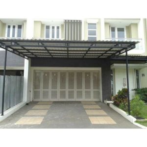 Kanopi besi hollow galvanis dengan rangka hitam dan atap spandek putih dipasang di area carport rumah minimalis dua lantai, memberikan perlindungan dari panas dan hujan dengan tampilan modern.