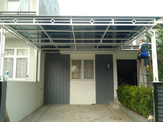 Kanopi galvalum modern dengan rangka baja ringan berwarna putih dan atap solid tidak tembus pandang, dipasang di halaman depan rumah minimalis untuk memberikan perlindungan dan privasi maksimal