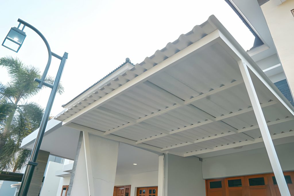 Kanopi rumah minimalis dengan atap alderon putih solid yang tidak tembus pandang, memberikan kesan elegan dan menjaga privasi penghuni rumah.