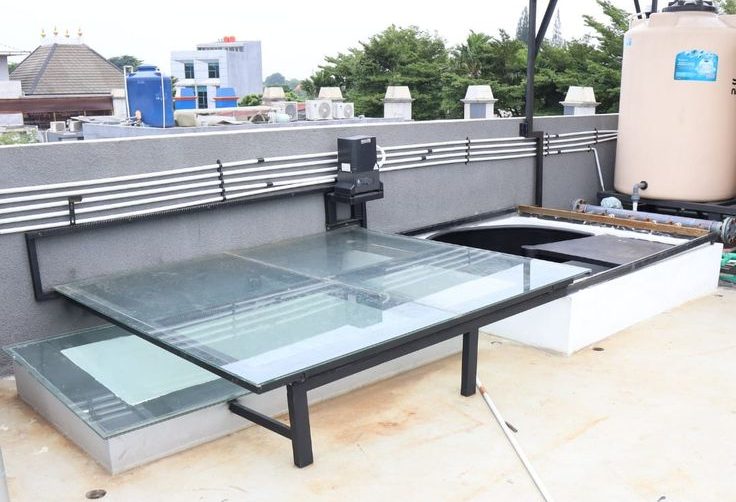 Kanopi Sliding Otomatis... Kanopi sliding otomatis berbahan kaca dengan sistem motorized di rooftop, memberikan kemudahan akses dan pencahayaan alami ke area bawah
