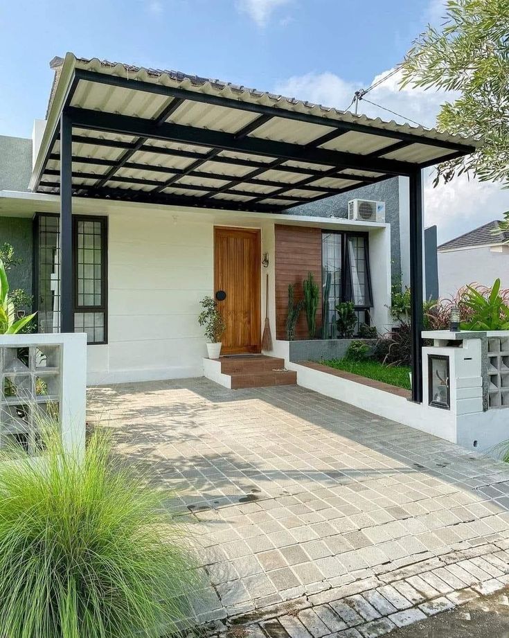Kanopi besi hollow hitam dengan atap alderon putih terpasang di depan rumah minimalis modern, memberikan perlindungan dan tampilan elegan pada area carport