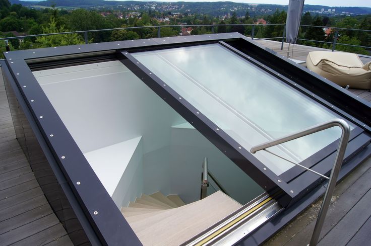 Contoh kanopi sliding manual kaca di rooftop rumah modern, dapat digeser untuk membuka dan menutup akses tangga.